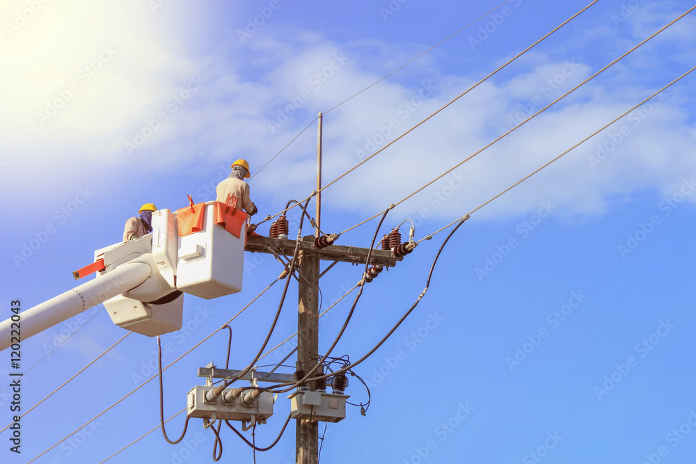 Electricians repairing wire of the power line on bucket hydraulic lifting Electricians repairing wire of the power line on bucket hydraulic lifting