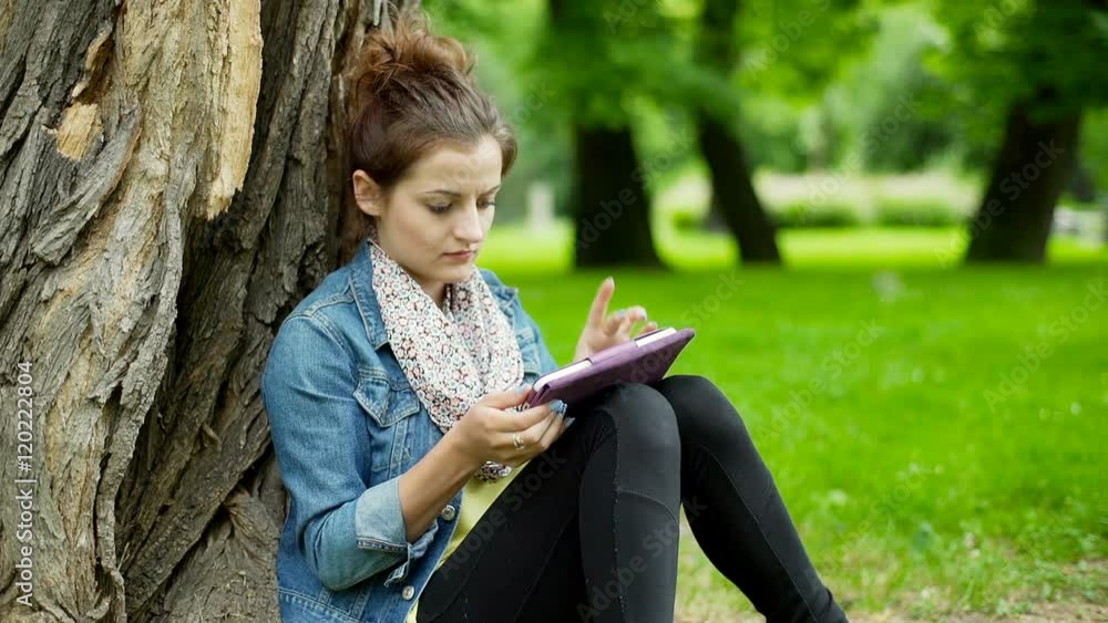 Girl browsing internet on smartphone and smiling to the camera in the park
Girl browsing internet on smartphone and smiling to the camera in the park