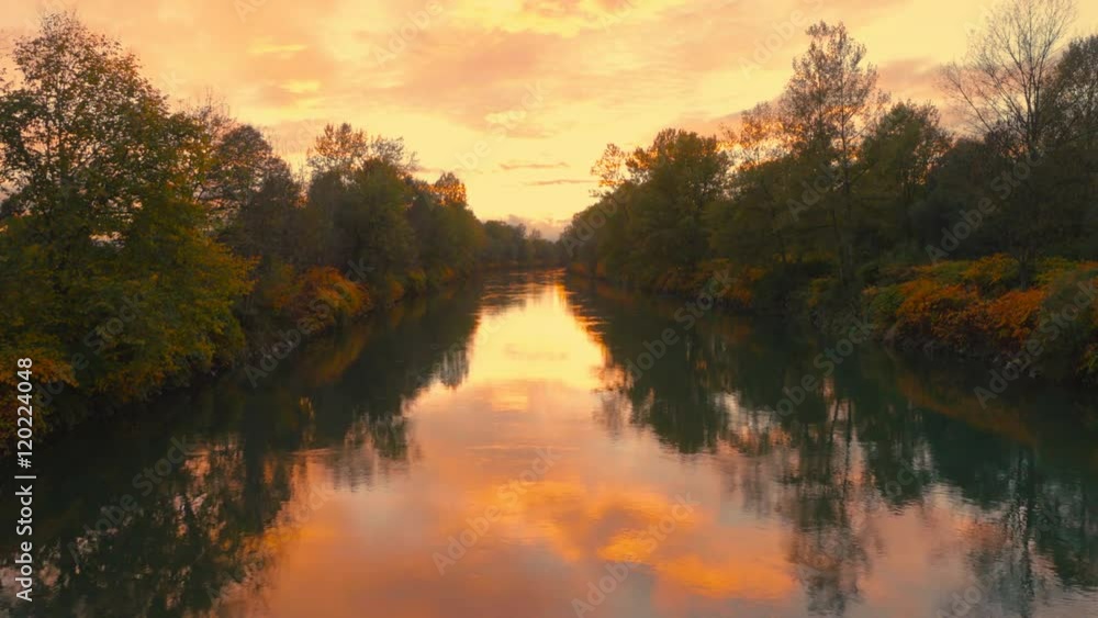 Aerial lift above autumn river bank at dusk
Aerial lift above autumn river bank at dusk