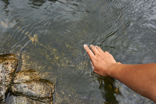 A hand touch natural water surface