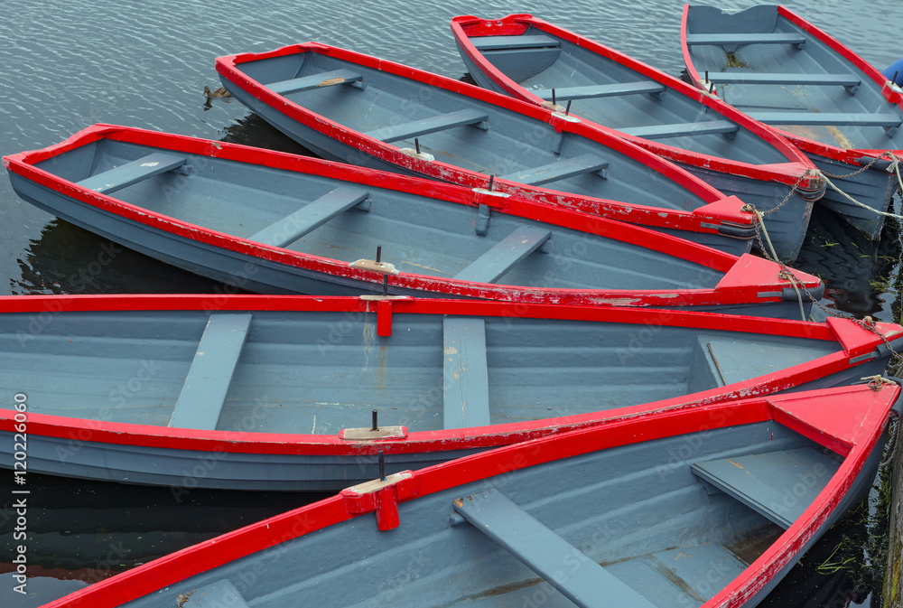 a group of red and grey rowboats