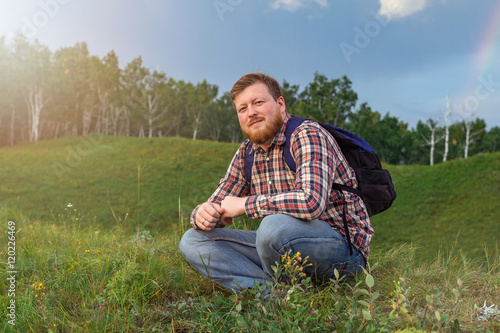 Man with a beard sits on a hill