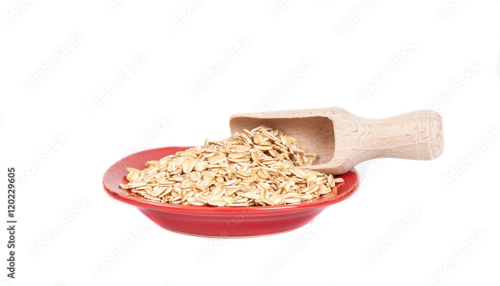 red dish with oats flakes pile on white background. red dish with oats flakes pile on white background.