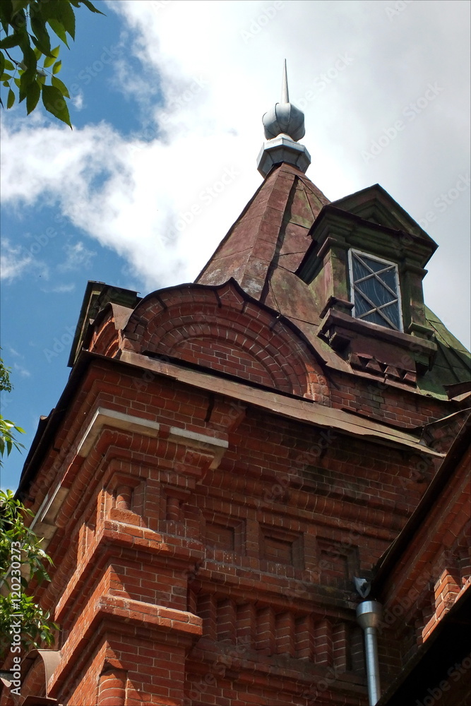 Фрагмент старого кирпичного здания с куполом  на фоне неба.