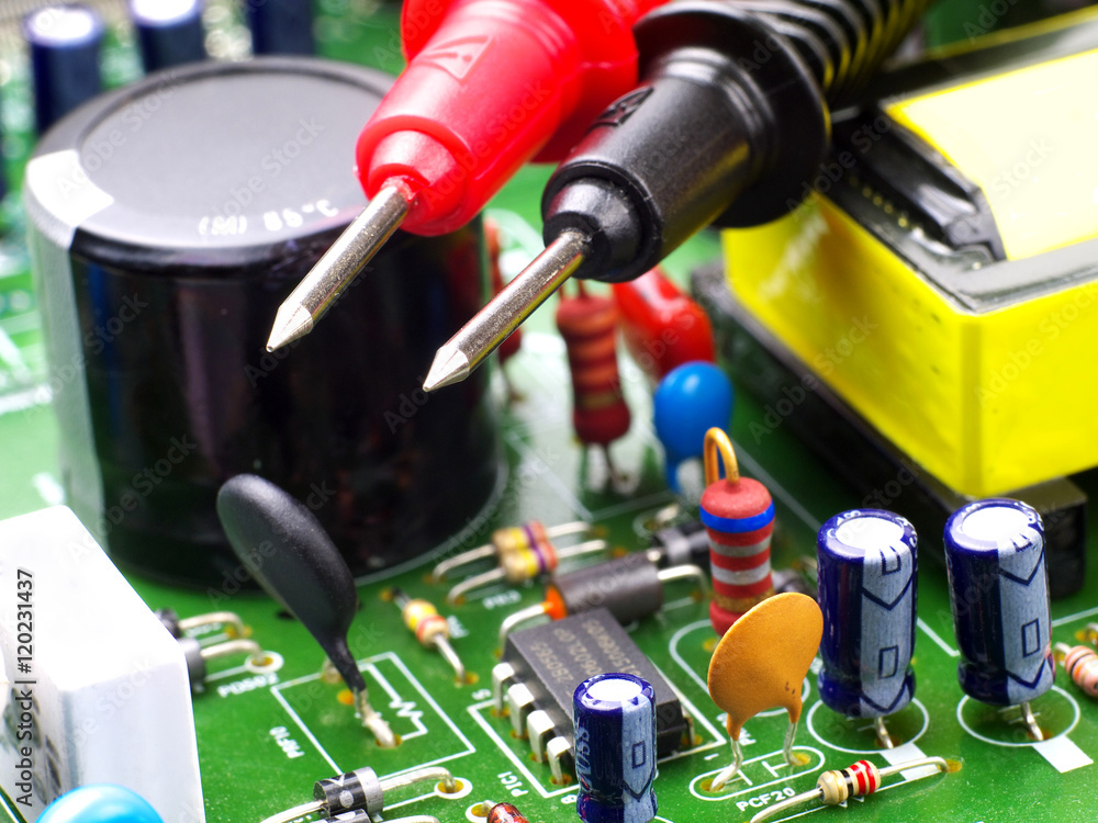 multimeter test probes on printed circuit board, closeup, shallow depth ...