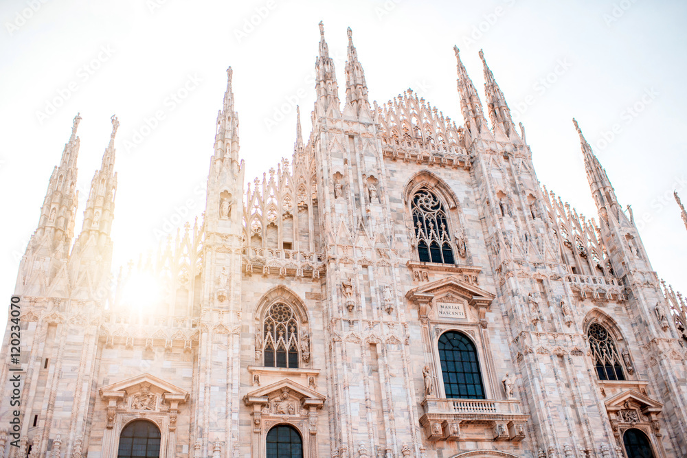 Main facade of the famous Duomo cathedral on the sunrise in Milan city in Italy