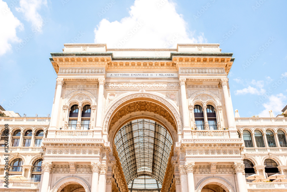 Main entrance facade of the famous Vittorio Emanuele shopping gallery in the center of Milan city.