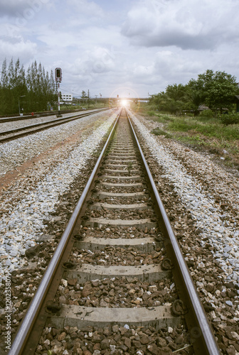 view of the length of railway with green tree at left and right side of railway.filtered image.light effect and flare added