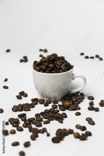 Coffee cup filled with coffee beans.