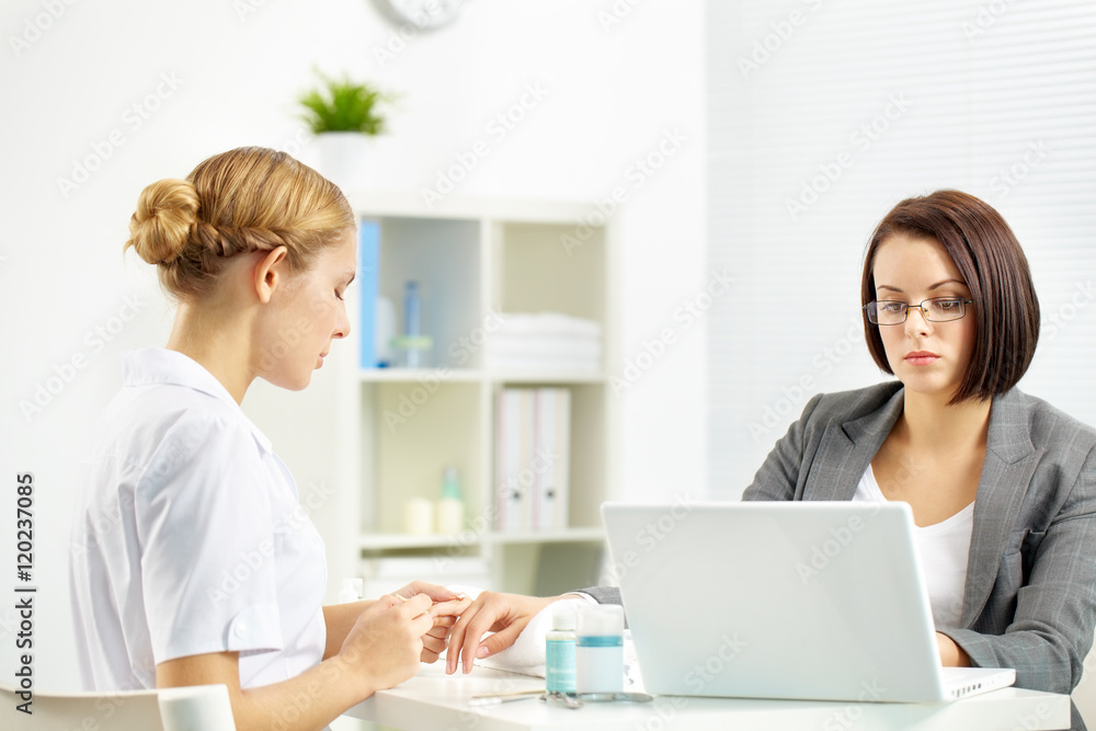 Beautician polishing businesswoman hand right in the office Beautician polishing businesswoman hand right in the office