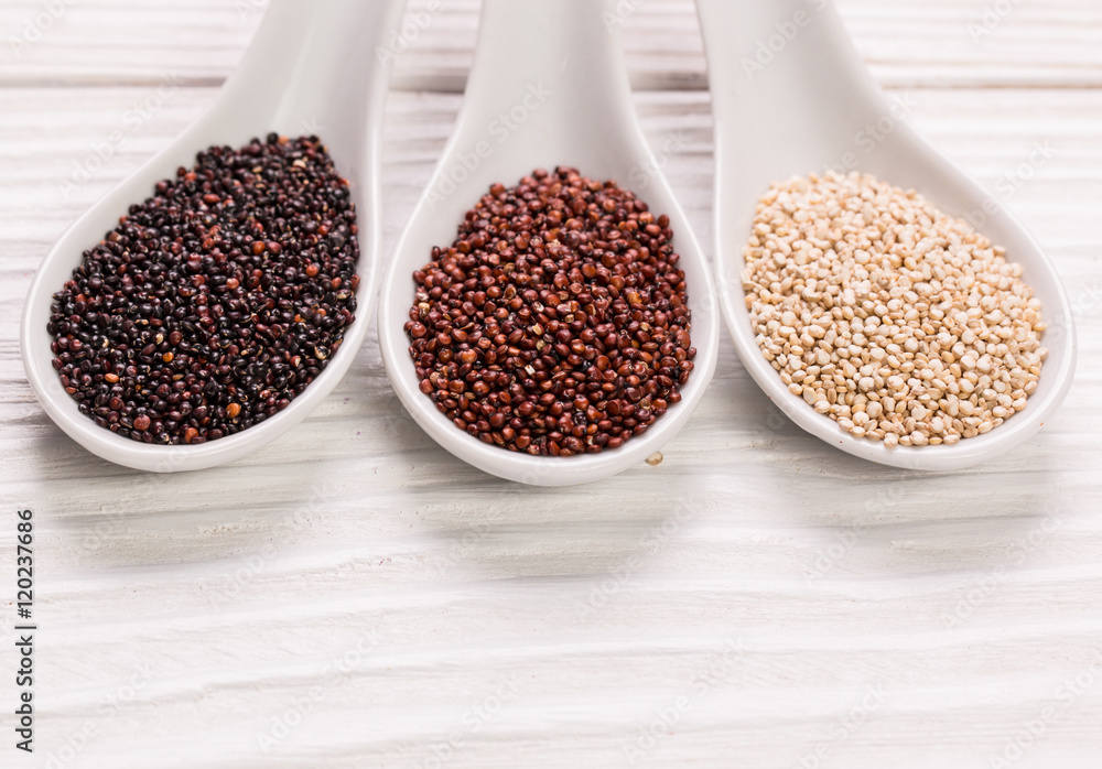 Red, black and white quinoa seeds on a wooden background Red, black and white quinoa seeds on a wooden background