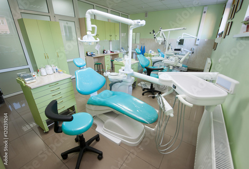 Dentist chairs with contemporary equipment at bright treatment room in dental practice