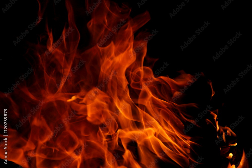 Closeup of a large fire. Wooden planks to the fire. The fire is lit in the night. Closeup of a large fire. Wooden planks to the fire. The fire is lit in the night.