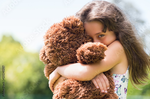 Girl embracing teddy bear photo