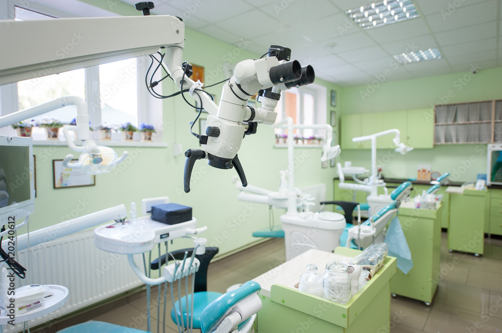 Close-up view of microscop in modern stomatological office on the background of dental chairs and other equipment used by dentists