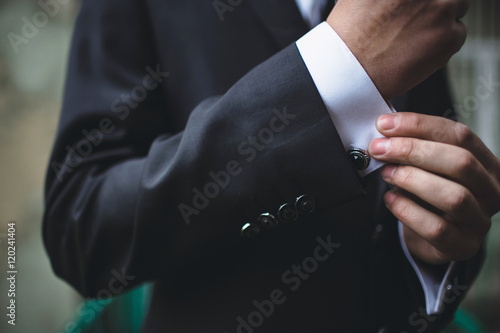 Cufflinks on the white shirt of the groom