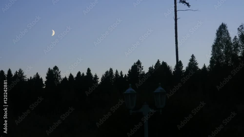 Time-lapse of half moon moving away above a yellow glowing lanterns Time-lapse of half moon moving away above a yellow glowing lanterns