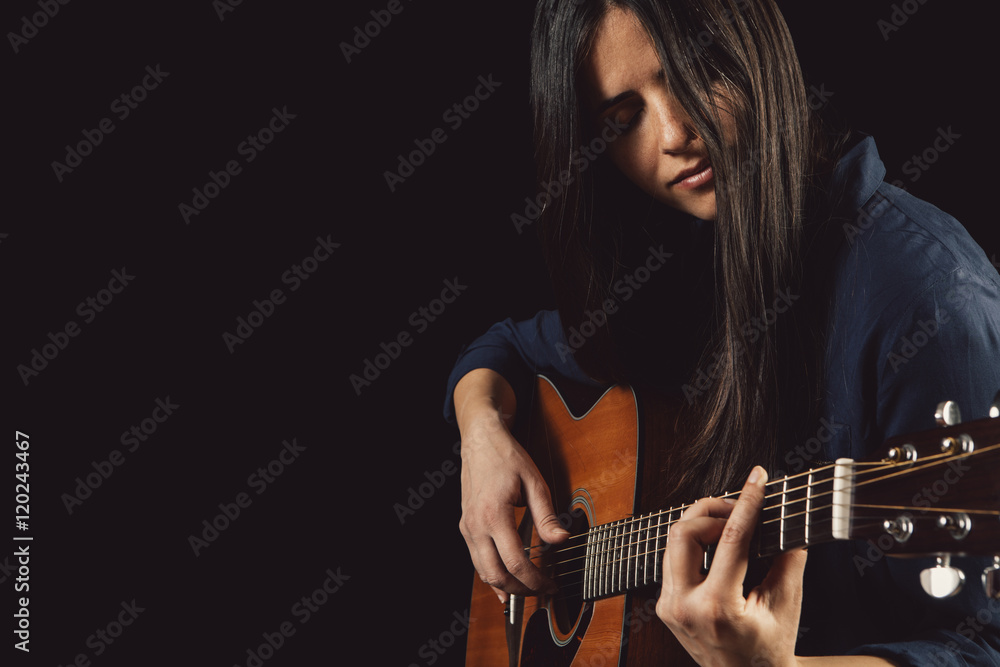 Fototapeta premium beautiful young woman playing acoustic guitar