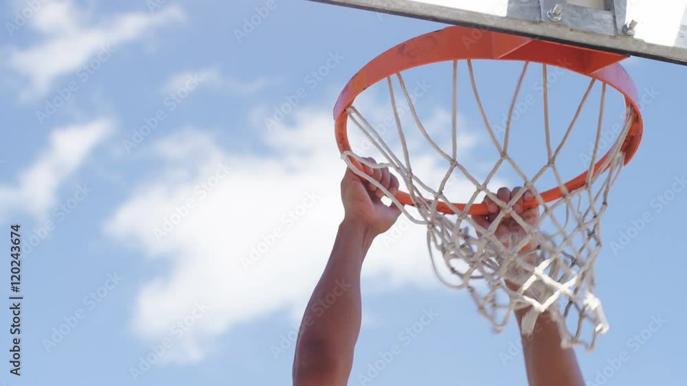 Close up of basketball player's hands slam dunking, in slow motion Close up of basketball player's hands slam dunking, in slow motion