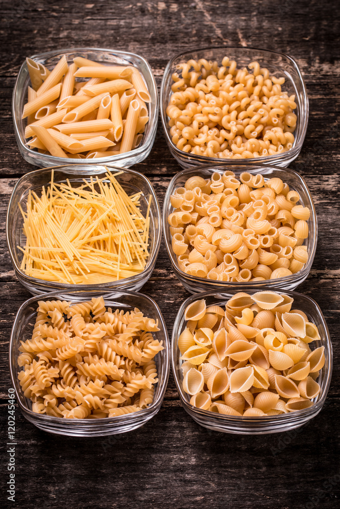 Various mix of pasta on wooden rustic background. Diet and food Various mix of pasta on wooden rustic background. Diet and food