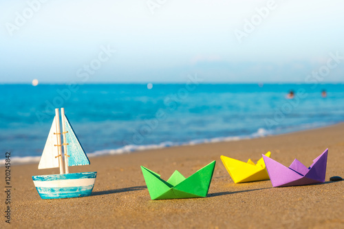 paper boats and wood boat at the seashore