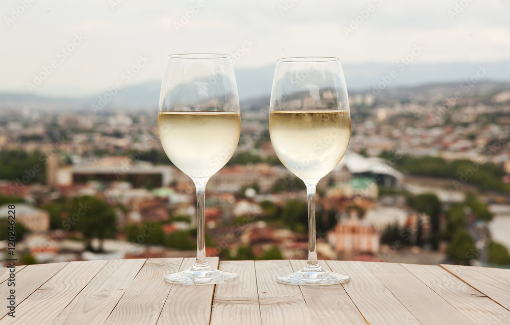 Obraz premium Two glasses on white wine on the table in Tbilisi, Georgia.