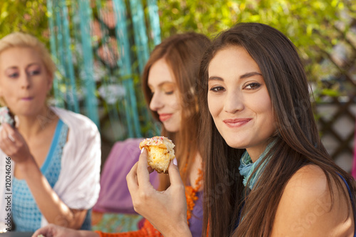 Junge Frau isst Muffin auf einer Party