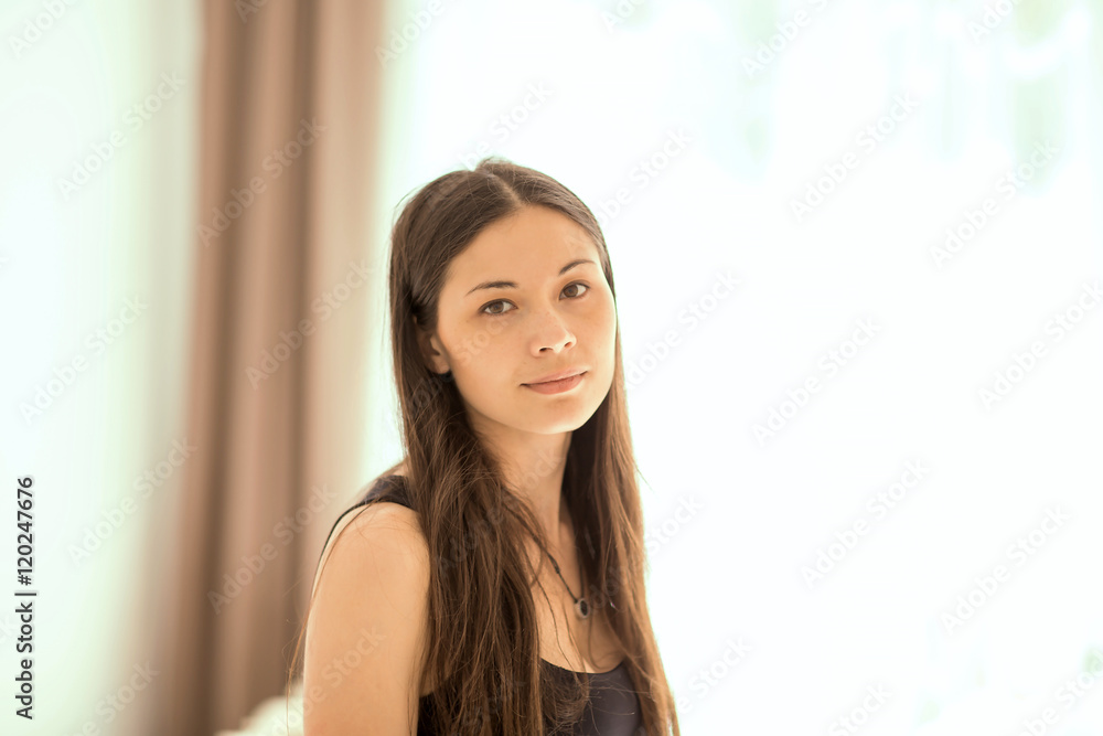portrait of a beautiful young woman at the window