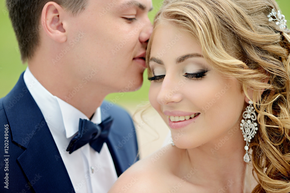 Wedding couple on the nature is hugging each other. Beautiful model girl in white dress. Man in suit. Beauty bride with groom. Female and male portrait. Woman with lace veil. Lady and guy outdoors Wedding couple on the nature is hugging each other. Beautiful model girl in white dress. Man in suit. Beauty bride with groom. Female and male portrait. Woman with lace veil. Lady and guy outdoors