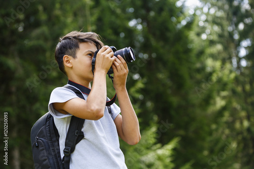 young boy takes pictures in nature