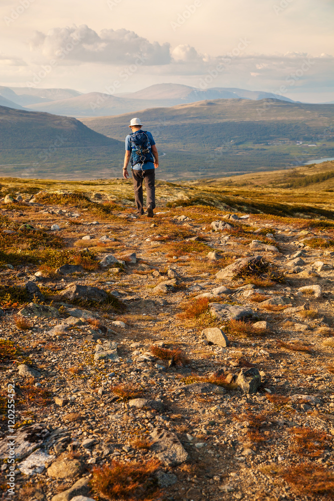 hiker with backpack traveling in Norway mountains Dovre