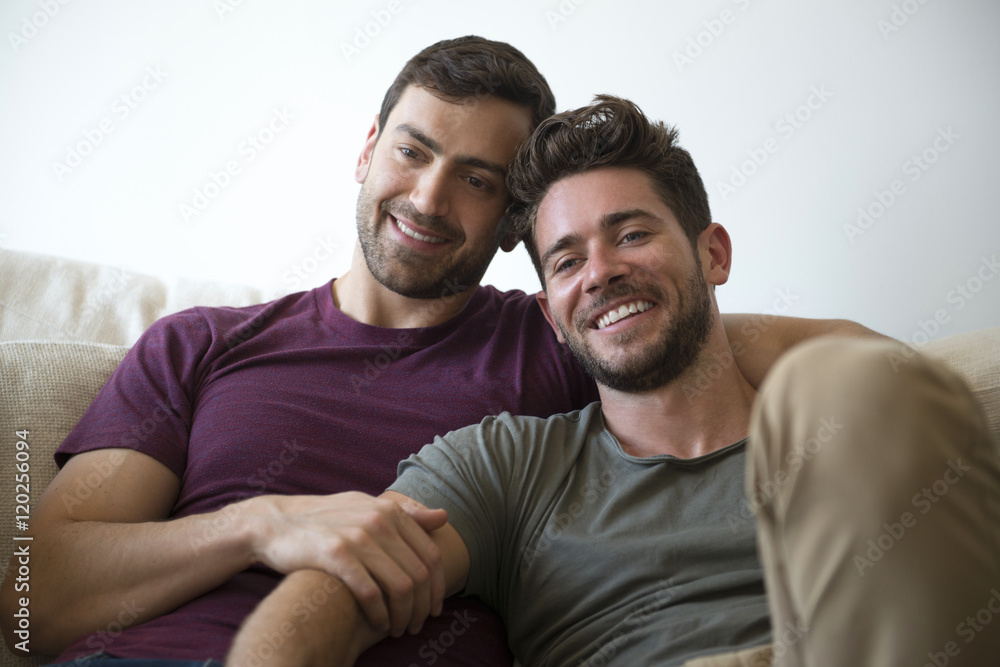 Gay Male Couple Relax On Sofa Watching TV Gay Male Couple Relax On Sofa Watching TV