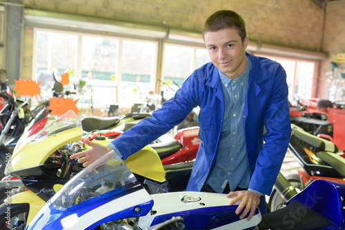young man buying motorbike in showroom