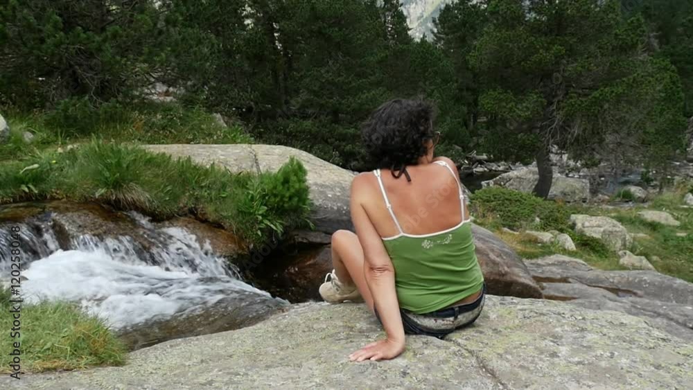 hiker woman rests on a rock in the mountains hiker woman rests on a rock in the mountains
