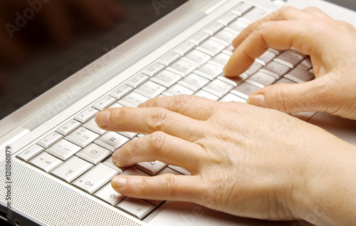 Close-up of female hands working on laptop