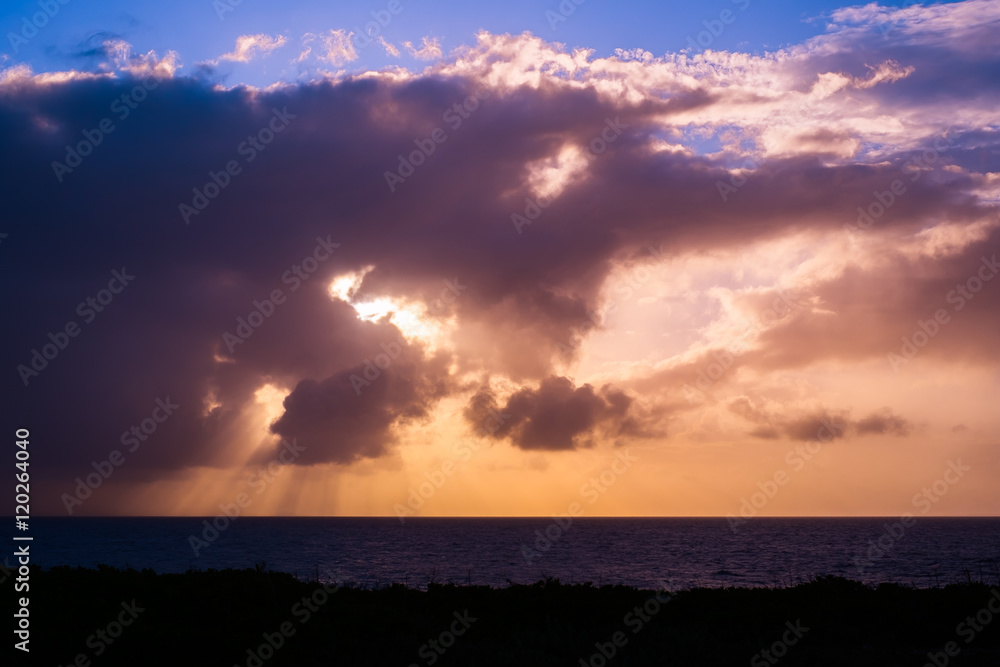 沖縄の海のオレンジ色の夕日と雲