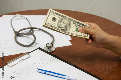 medical prescription and hand holding US dollar notes symbol for health care costs or medical insurance