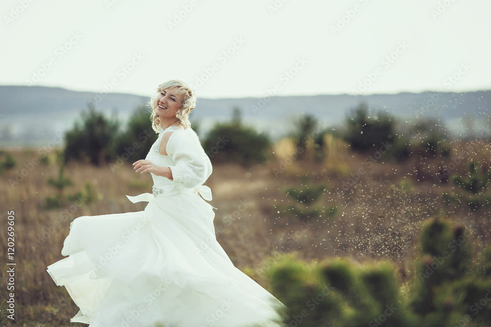 Bride posing on field. Portrait of a blonde girl in a wedding Bride posing on field. Portrait of a blonde girl in a wedding
