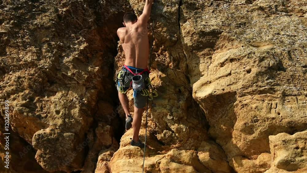 Muscular Climber Climbing Without Insurance On A Cliff. Muscular Climber Climbing Without Insurance On A Cliff.