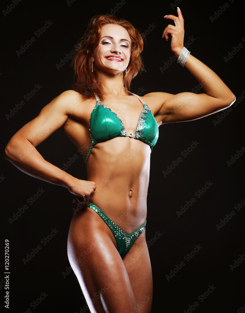 Fototapeta premium blond bodybuilder woman in bikin on black background