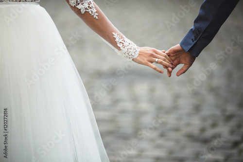 bride and groom hold each other's hands