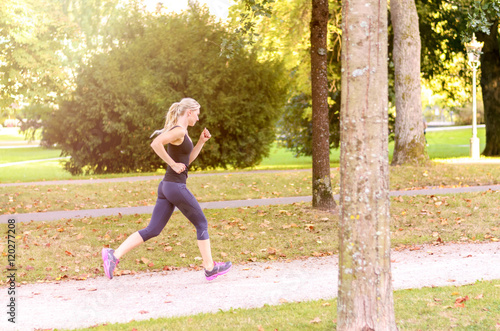 Fit active young woman jogging through a park