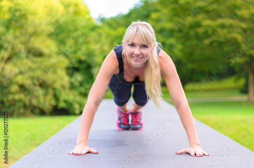 Fit young blond woman doing exercises in a park