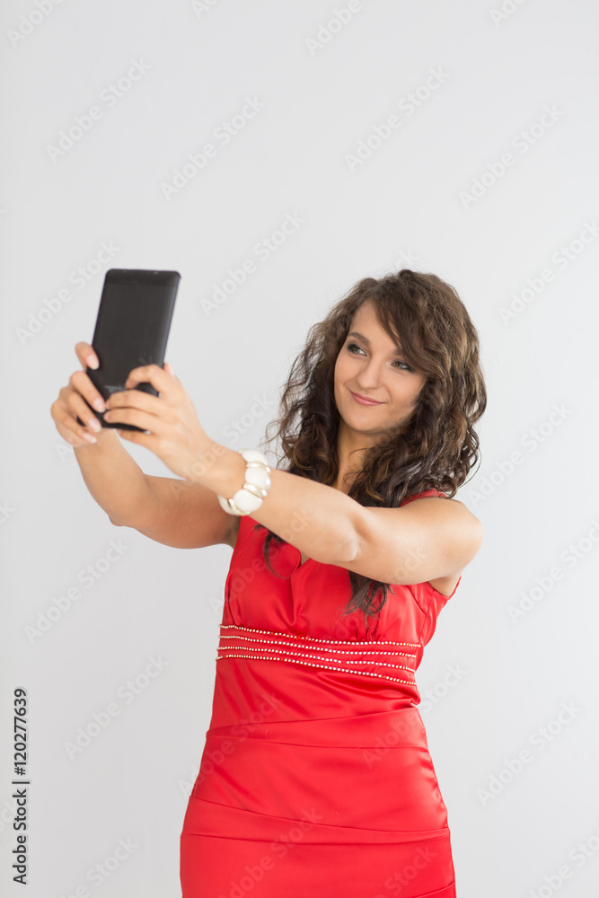 Naklejka premium pretty girl make a duck face, and take a self portrait with her smart phone 