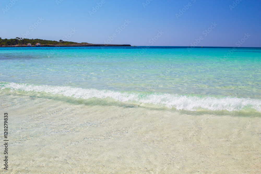 Clear water and white sand at Cala Son Saura beach, Menorca.