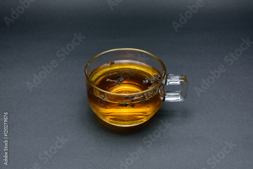 Clear glass of tea isolated on black background.