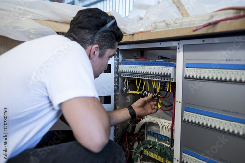 Young electrician repairing boat control 