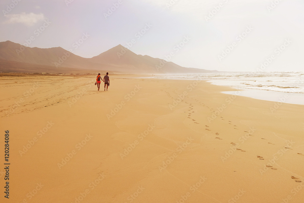 A couple walking holding hands on the beach Cofete on Fuertevent A couple walking holding hands on the beach Cofete on Fuertevent