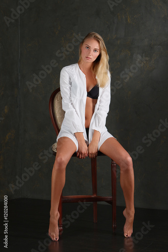 Pretty blonde woman in black lingerie and mens shirt. Provocativ