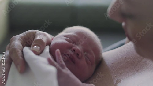 Close Up of Newborn Baby Dreaming on Mothers Chest in Hospital Delivery Room